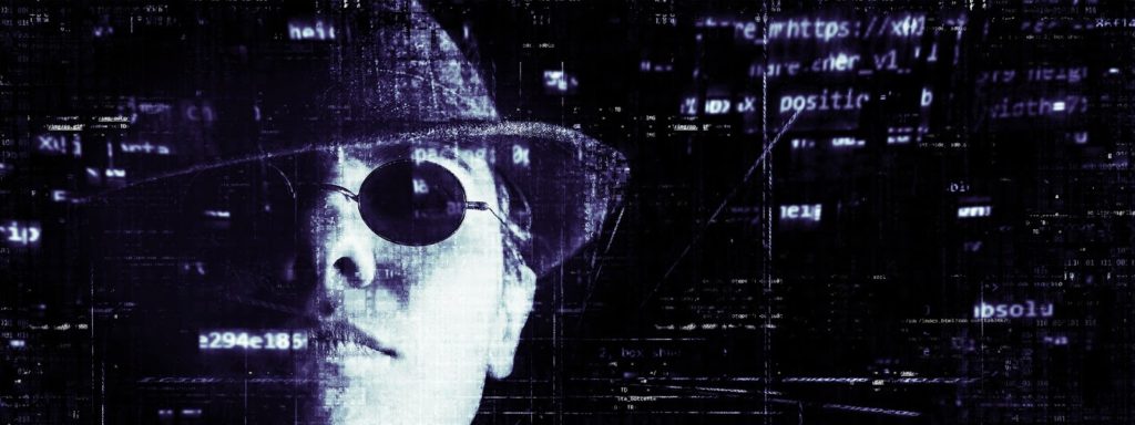 Image of a man wearing a hat and dark glasses with some computer code surrounding him.