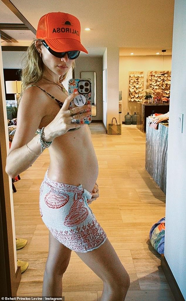 Stylish mama: The supermodel uploaded a second snap of herself posing in printed linen shorts and a bikini top to better flaunt her baby bump in the selfie