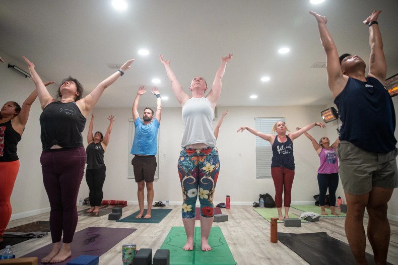 Jessi LaPointe, center, does vinyasa hot yoga at SOMOS on Monday, June 7, 2022, in Corpus Christi, Texas. 