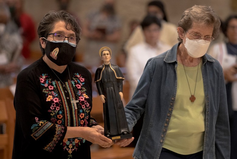 People carry a figurine of Saint Toribio Romo, the patron saint of immigrants, during a memorial mass to honor the victims of the human smuggling tragedy at the San Fernando Cathedral on Thursday.
