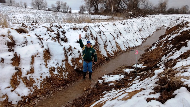 Scott Koehnke, a water management specialist for the Wisconsin Department of Natural Resources, demonstrates the depth of the illegal dredging done to a navigable stream in Greenville in late 2016. For a frame of reference, Koehnke is 6-foot-3.