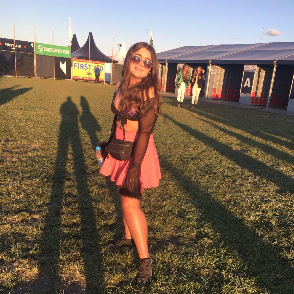 Jess Prinsloo poses as a festival wearing a pink skirt and sunglasses.