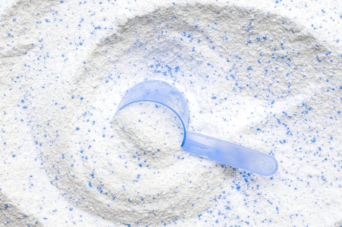 blue scooper in powder laundry detergent