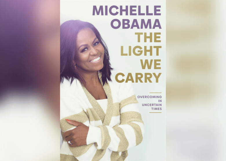 Michelle Obama in a gold and white striped sweater.