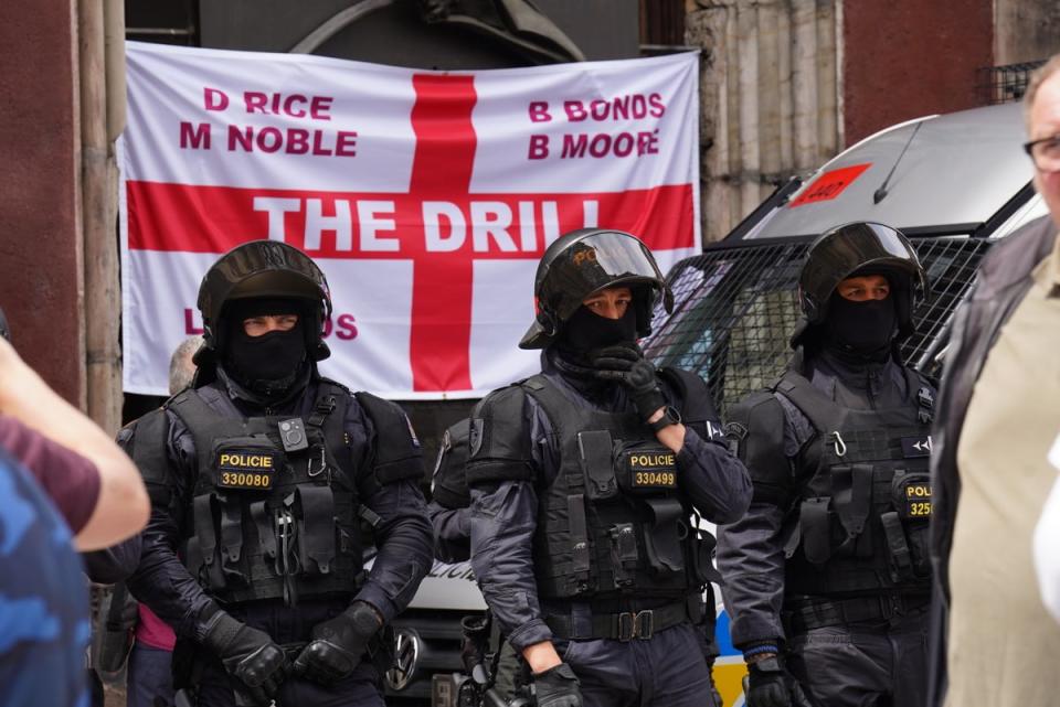 Police in riot gear watch West Ham United supporters (James Manning/PA Wire)