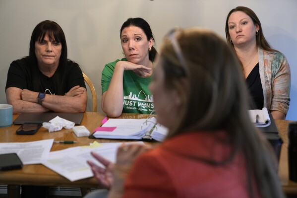Co-founders of Just Moms STL, Karen Nickel, left, and Dawn Chapman listen along with Ashley Bernaugh, right, as Missouri Rep. Tricia Byrnes, foreground, discusses nuclear contamination in and around the St. Louis area Friday, April 7, 2023, in Maryland Heights, Mo. (AP Photo/Jeff Roberson)