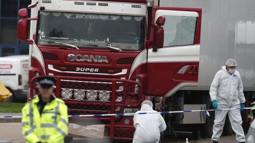 FILE - Forensic police officers attend the scene after a truck was found to contain a large number of dead bodies, in Grays, England, Oct. 23, 2019. A Romanian man who was part of an international human smuggling ring was sentenced Tuesday July 11, 2023, to more than 12 years in prison for the deaths of 39 migrants from Vietnam who suffocated were found lifeless in a truck trailer in England in 2019. Marius Mihai Draghici, 50, pleaded guilty last month to 39 counts of manslaughter and conspiracy to assist unlawful immigration. (AP Photo/Alastair Grant, File)