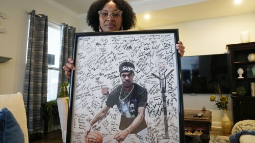 Pamela White poses in her home in Ponchatoula, La., with a photo of her son Dararius Evans, who was killed in January of 2020, Thursday, May 4, 2023. White and her family turned to Louisiana’s victim compensation board for help paying for the unexpected funeral. She was met with administrative hurdles, a denial that blamed her son for his own death, a lengthy appeal — all while paying up front through a personal loan that gathered interest as she waited. (AP Photo/Gerald Herbert)