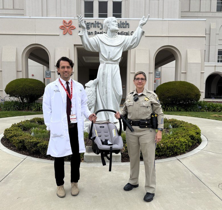 Dr. Kevin Rodriguez, left, a trauma surgeon at Marian Regional Medical Center, and California Highway Patrol Officer Maria Barriga display an approved child safety seat. Rodriguez and Barriga are working to inform community members about the dangers of using unapproved child safety seats.