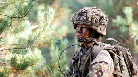 Getty Images A female soldier of 1st Battalion London Guards takes part in a training exercise on Hankley Common on October 16, 2024 in Farnham, England.