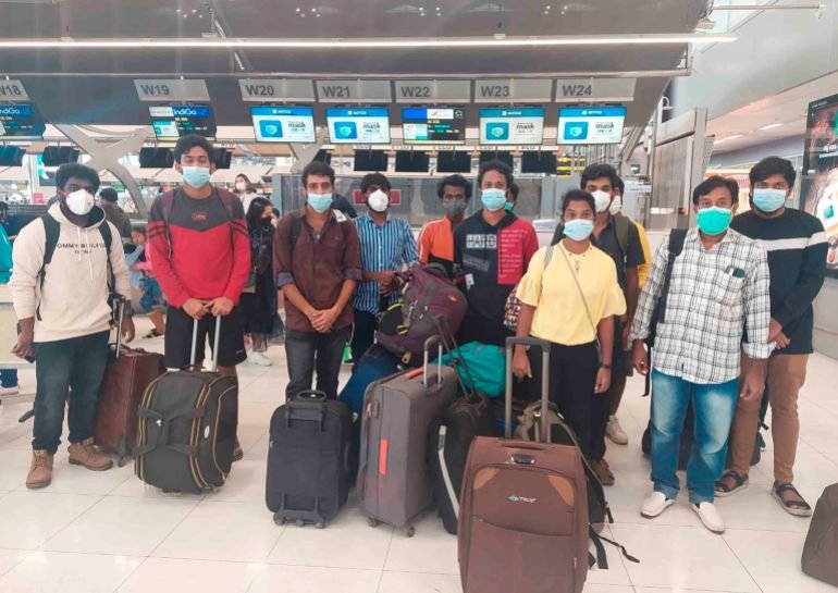 In this photo provided by the Ministry of External Affairs, Indian workers rescued after they were lured by agents for fake job opportunities in the information technology sector in Thailand arrive at the airport in Chennai, India, Wednesday, Oct. 5, 2022. Arindam Bagchi, the External Affairs Ministry spokesperson, said some fraudulent IT companies appear to be engaged in digital scamming and forged cryptocurrencies. The Indian workers were held captive and forced to commit cyber fraud, he told reporters. (Ministry of External Affairs via AP)