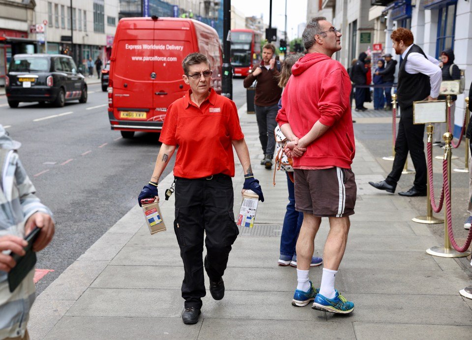 A delivery person carrying two parcels outside the Sherlock Holmes Museum.
