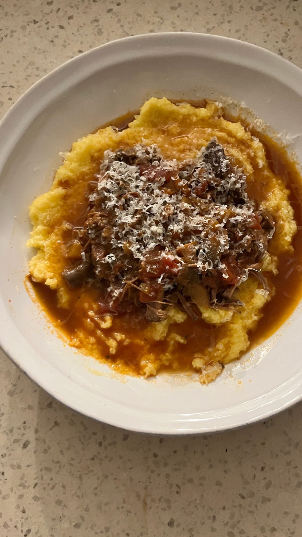 bowl of polenta topped with beef ragu
