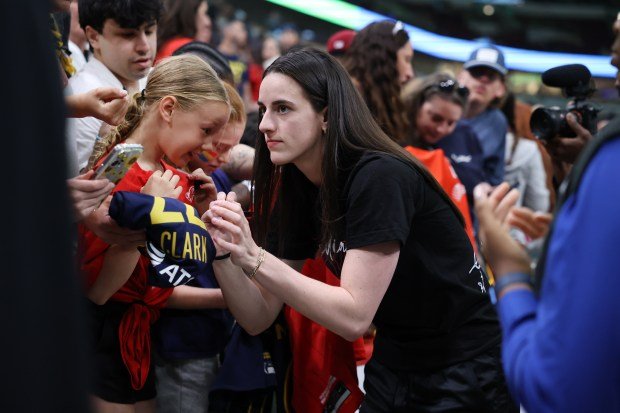 Injured Indiana Fever guard Caitlin Clark signs autographs for fans before a game against the Sky on June 7, 2025, at the United Center. (Chris Sweda/Chicago Tribune)