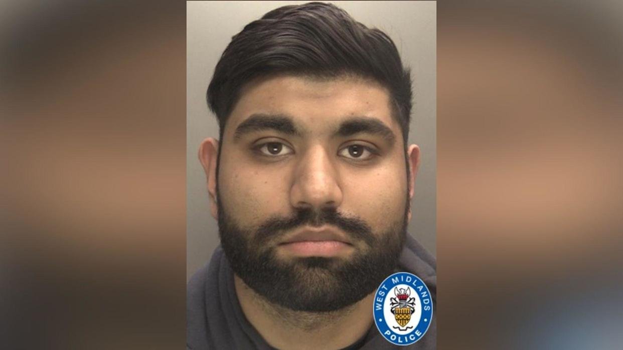 Aaron Kaninth - a custody image of a man with a short black mustache and beard, thick eyebrows and a straight black hair