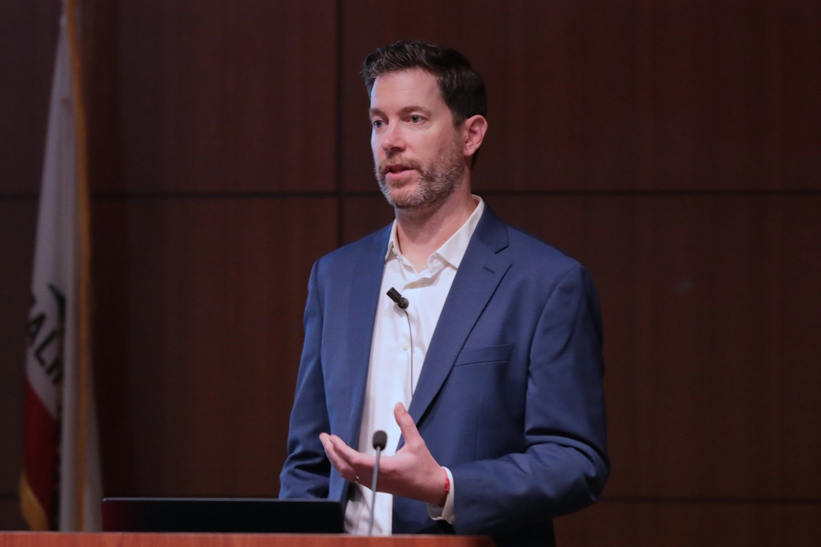 Adam Dodge speaking to audience wearing a blue blazer.